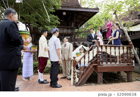 a group of people is standing and staring at the groom on Thai wedding. 32090638