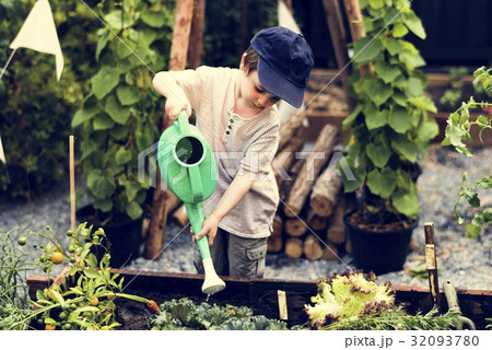 Children are in the garden watering the plants 32093780