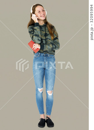 Teenage girl smiling and listening music by headphones 32095994