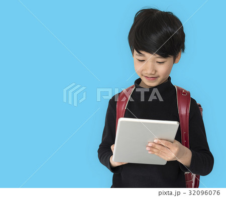 A boy with a backpack and tablet. 32096076