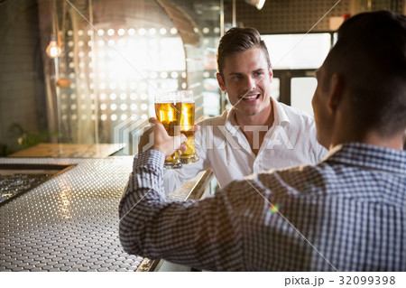 Two men toasting a glass of beer 32099398