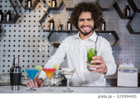 Bartender serving glass of gin 32099400
