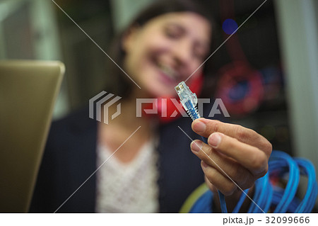 Technician holding internet cable in server room 32099666