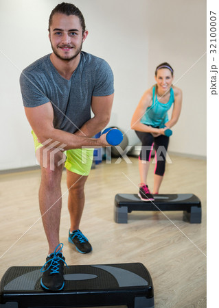 Portrait of man and woman doing aerobic exercise with dumbbell 32100007