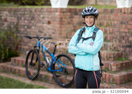 Portrait of female biker standing with arms crossed 32100094