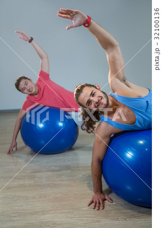 Men exercising with exercise ball 32100136