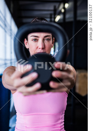 Portrait of serious athlete showing kettlebell Portrait of serious athlete showing kettlebell 32100137