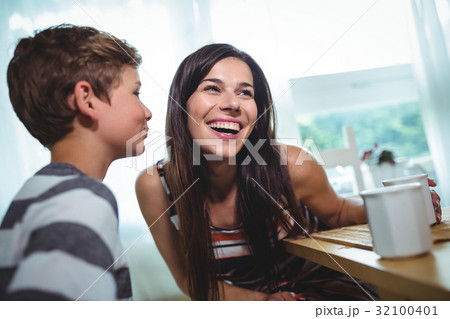 Boy whispering to his mother Boy whispering to his mother 32100401