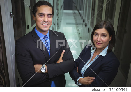 Technicians standing with arms crossed in a server room 32100541