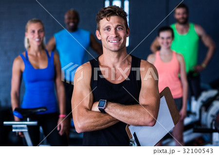 Portrait of smiling gym trainer holding clipboard 32100543