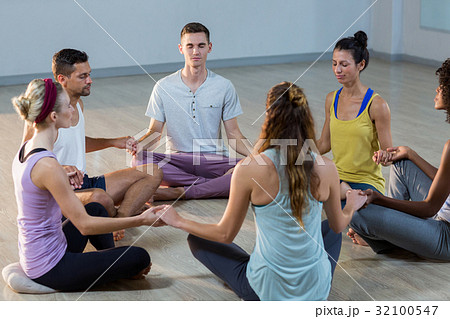 Group of people performing yoga 32100547