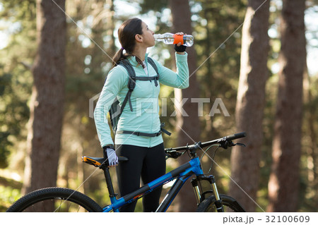 Female biker drinking water 32100609