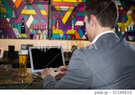 Man using laptop in bar 32100610