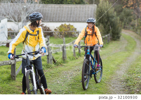 Biker couple interacting while cycling 32100930