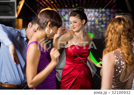 Smiling friends dancing on dance floor Smiling friends dancing on dance floor 32100932