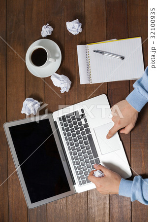 Man using laptop while writing on notepad Man using laptop while writing on notepad 32100935