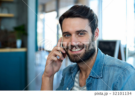 Smiling man talking on mobile phone Smiling man talking on mobile phone 32101134