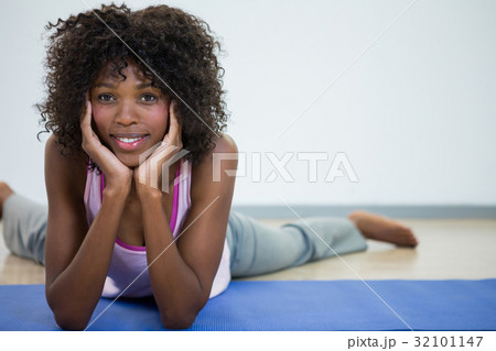 Portrait of woman lying on front with hands on chin 32101147