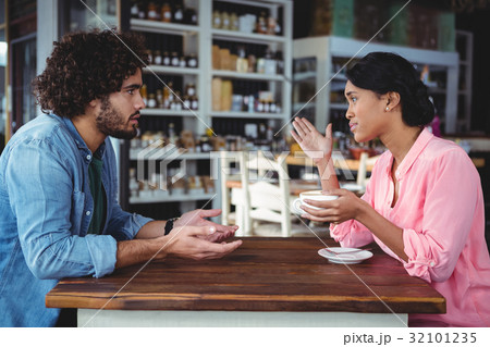 Couple interacting with each other while having coffee Couple interacting with each other while having coffee 32101235