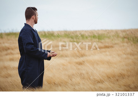 Farmer standing in field and looking view Farmer standing in field and looking view 32101337