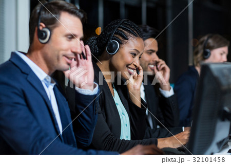 Colleagues with headsets using computer at office 32101458