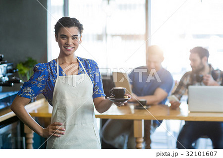 Portrait of waitress holding cup of coffee 32101607