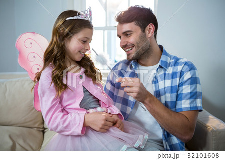 Girl dressed up in a fairy costume interacting with father 32101608