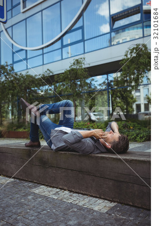 Business executive lying on wood and listening music 32101684