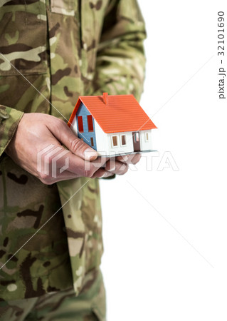 Mid section of soldier holding a model home Mid section of soldier holding a model home 32101690