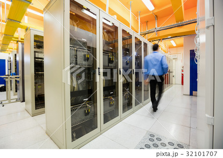 Technician walking in server room 32101707