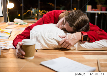Tired businesswoman sleeping on the desk 32101941