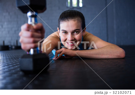 Happy female athlete holding dumbbell 32102071