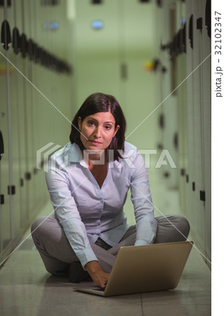 Portrait of technician siting on floor and using laptop Portrait of technician siting on floor and using laptop 32102347