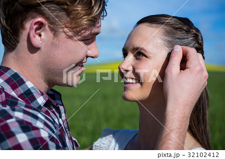 Romantic couple looking at each other in field 32102412