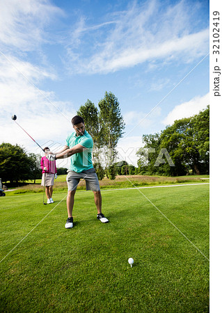 Male instructor assisting woman in learning golf 32102419