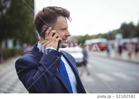 Handsome businessman talking on mobile phone Handsome businessman talking on mobile phone 32102582