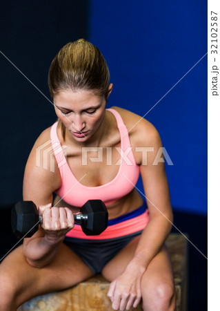 Woman exercising with dumbbell in fitness studio Woman exercising with dumbbell in fitness studio 32102587