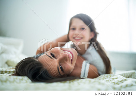 Portrait of mother and daughter lying in bedroom Portrait of mother and daughter lying in bedroom 32102591