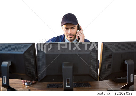Security officer talking on phone while using computer 32103058