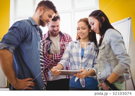 Businesswoman showing digital tablet with coworkers Businesswoman showing digital tablet with coworkers 32103074