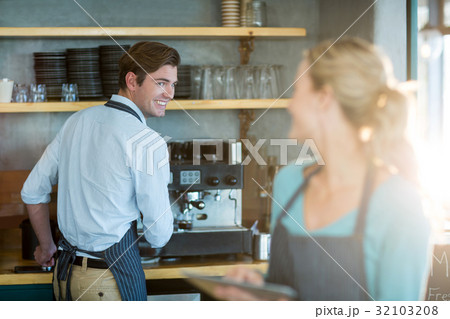 Waiter and waitress working in kitchen at cafÃƒÂ© 32103208