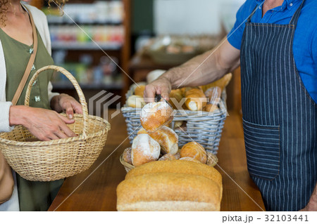 Mid section of woman purchasing bread at bakery store 32103441