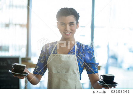 Portrait of waitress holding cup of coffee 32103541