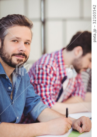 Close-up of handsome executive with colleague at creative office Close-up of handsome executive with colleague at creative office 32103542