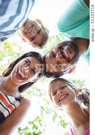 Family forming huddle against sky 32103718