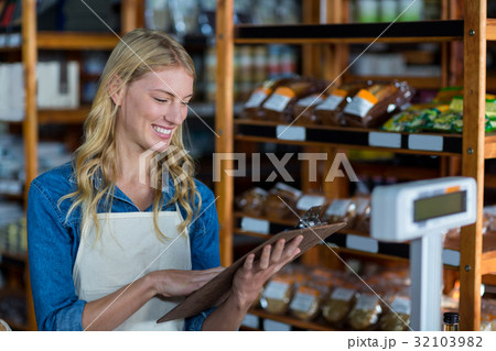 Smiling female staff looking at clipboard 32103982