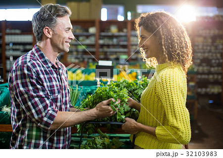 Happy couple buying vegetables in organic section 32103983