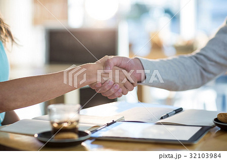 Friends shaking hands in cafÃƒÂ© 32103984
