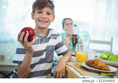 Smiling boy holding an apple 32104003
