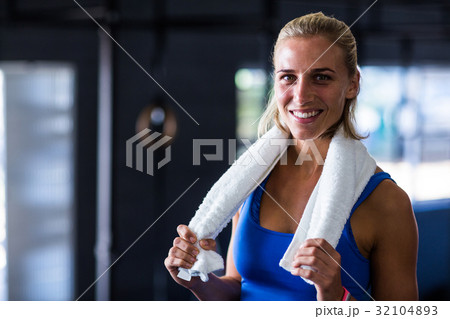 Portrait of happy fit woman with towel in gym Portrait of happy fit woman with towel in gym 32104893